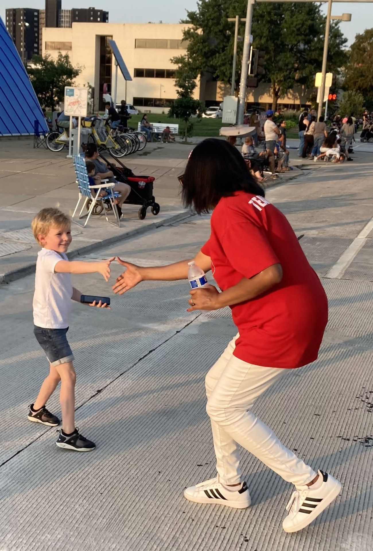 A MAGA Nation Iowa member greeting a young supporter at a parade